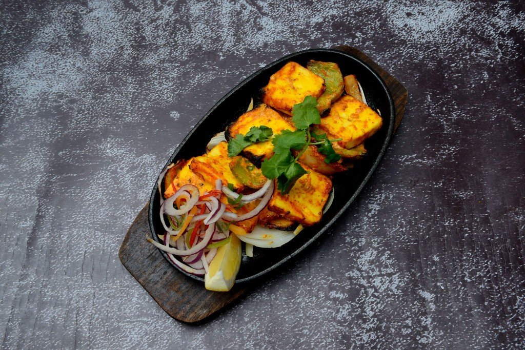 Paneer tikka on a sizzling platter